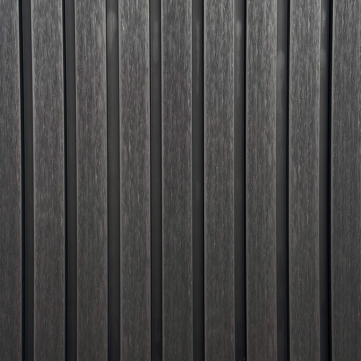 Close-up of charcoal outdoor vertical slat wall with a textured grain finish.