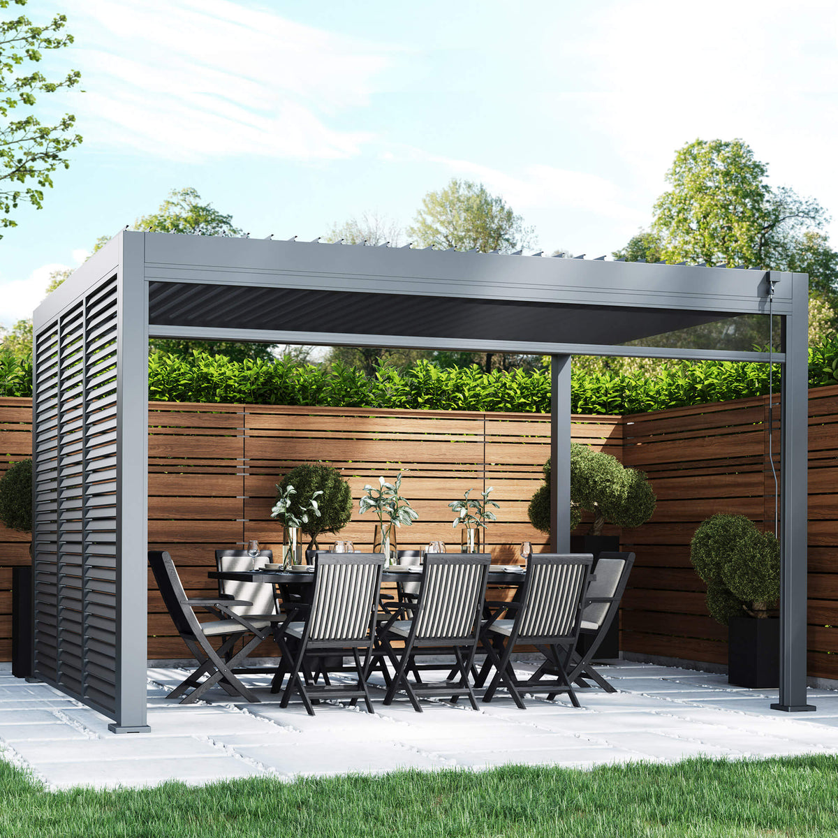 A Riva 4x3m Aluminium Pergola, dining table, and chairs in an outdoor patio setting.