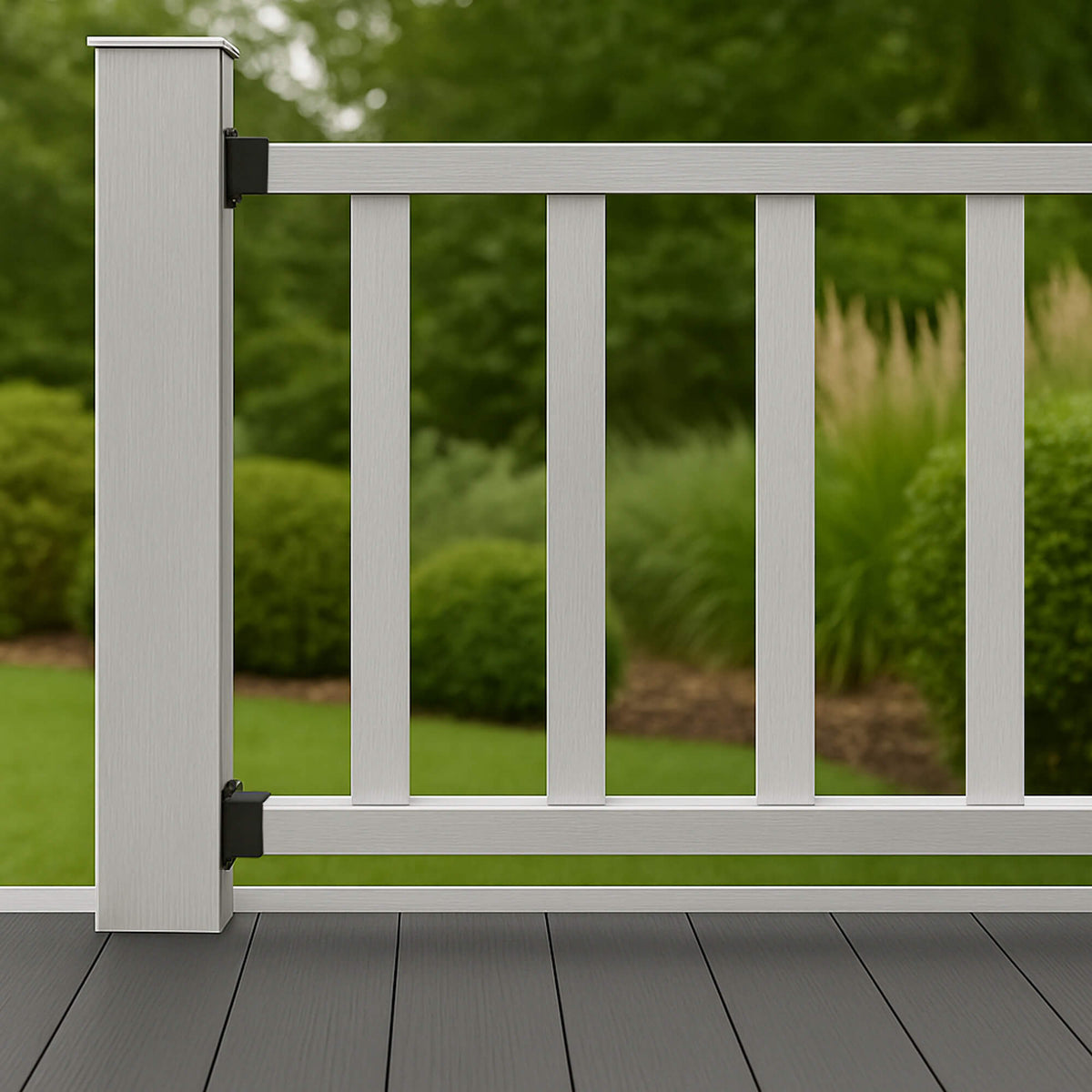 Sliver Composite Spindles in a garden fence on a deck with greenery in the background.